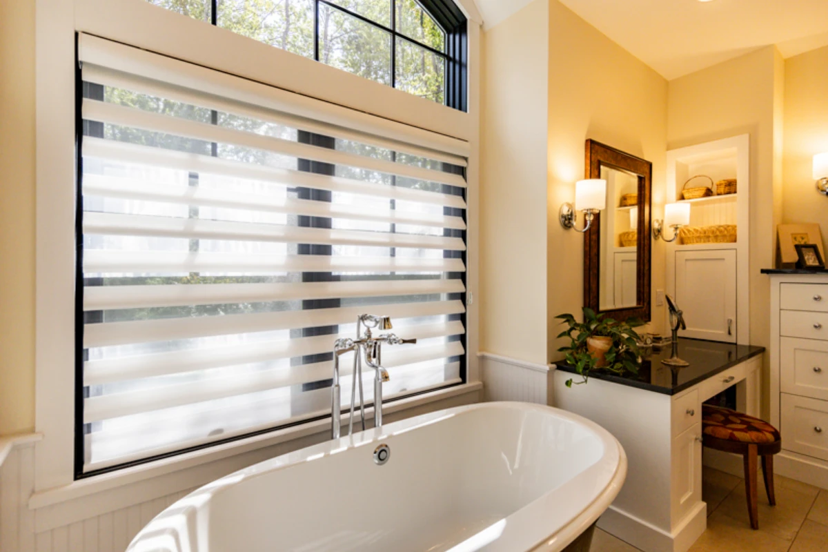 A primary bath with a freestanding tub under a wide window