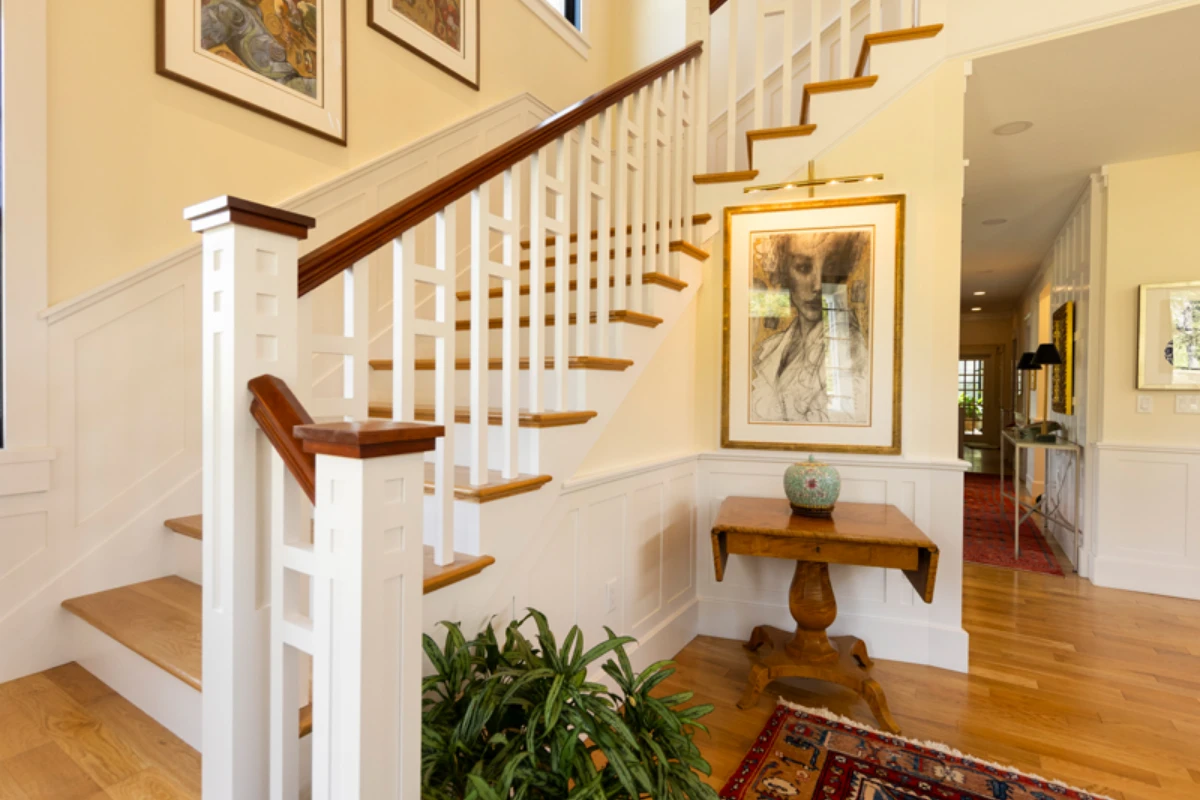 A white staircase with a stained handrail in a new custom home
