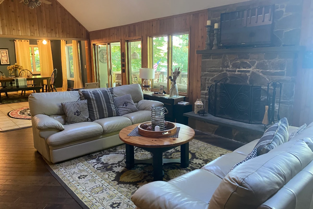 The same lake house living room before, with wood-paneled walls