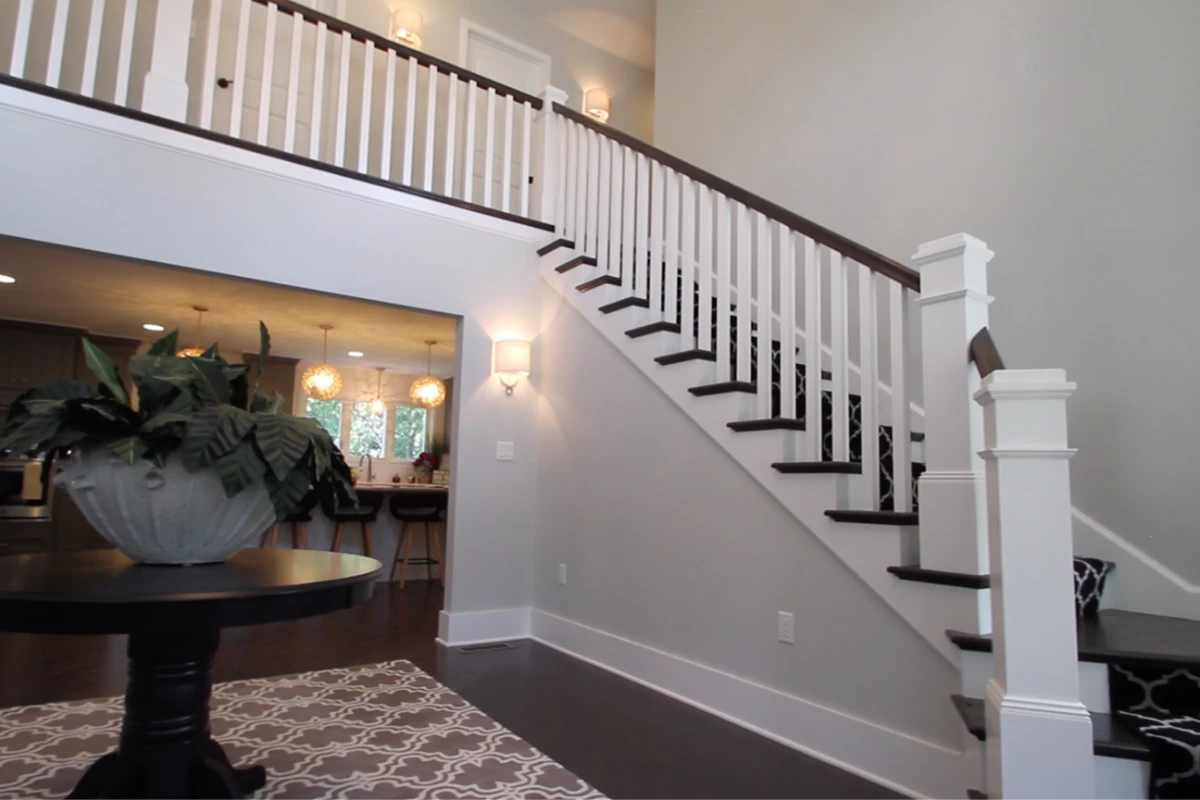 A white staircase with black treads rising to a new second floor