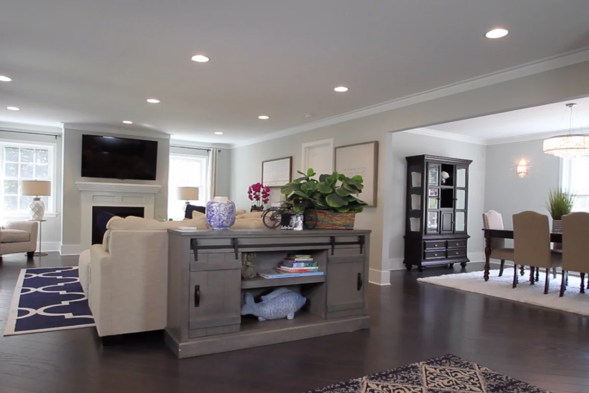 An open living and dining room with a fireplace, in a ranch rebuilt as a two-story house