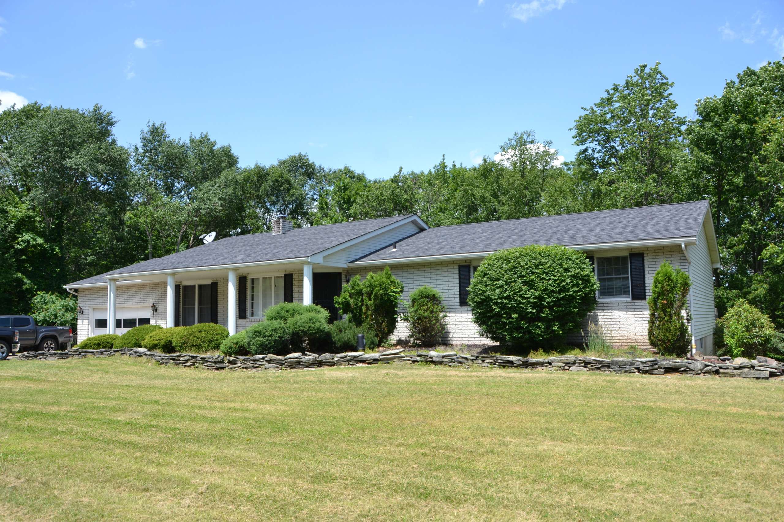 The same house before, a single-story ranch with a gray roof