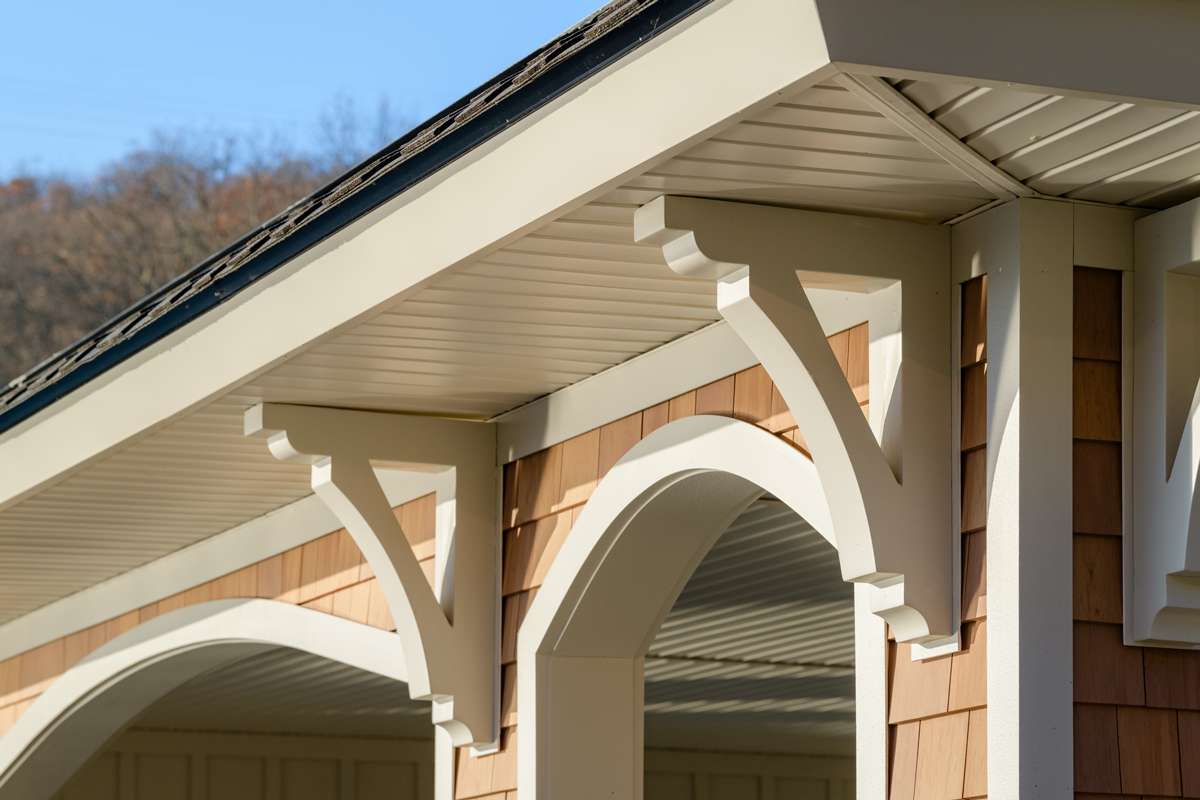 Porch brackets and arched trim under a shingled gable