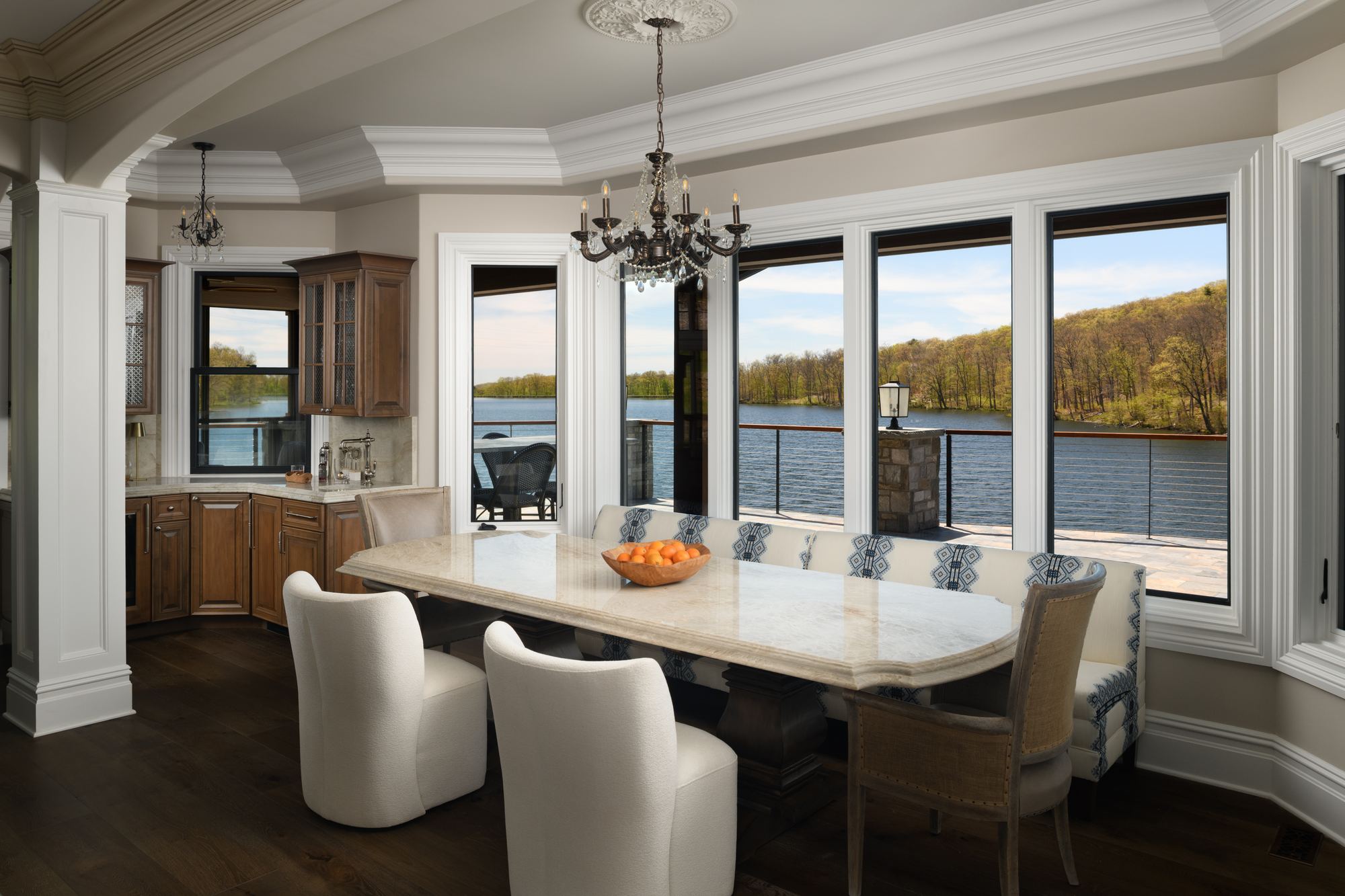 Breakfast room with a long table and a wall of windows over the lake