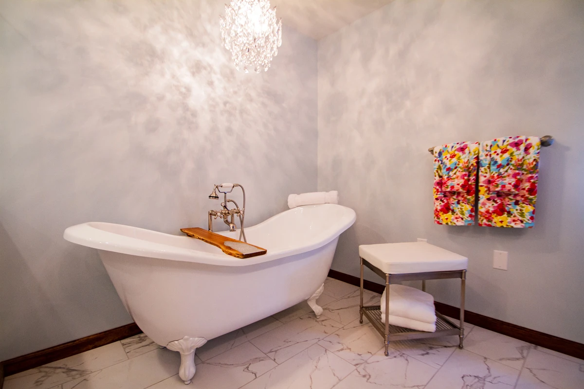 A crystal chandelier over a clawfoot tub