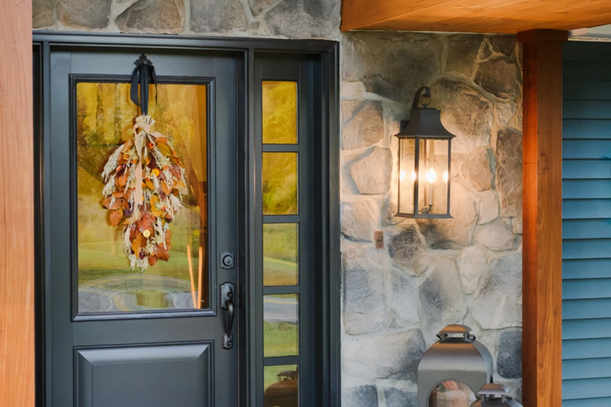 A black front door with a sidelight and lantern