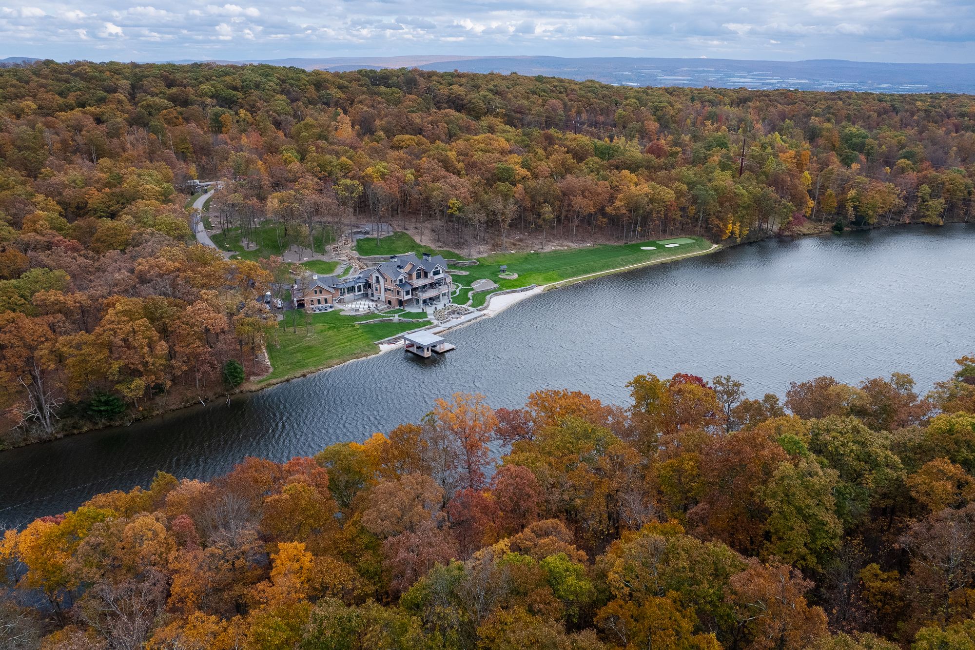 Aerial view of the estate on the lakeshore among autumn woods
