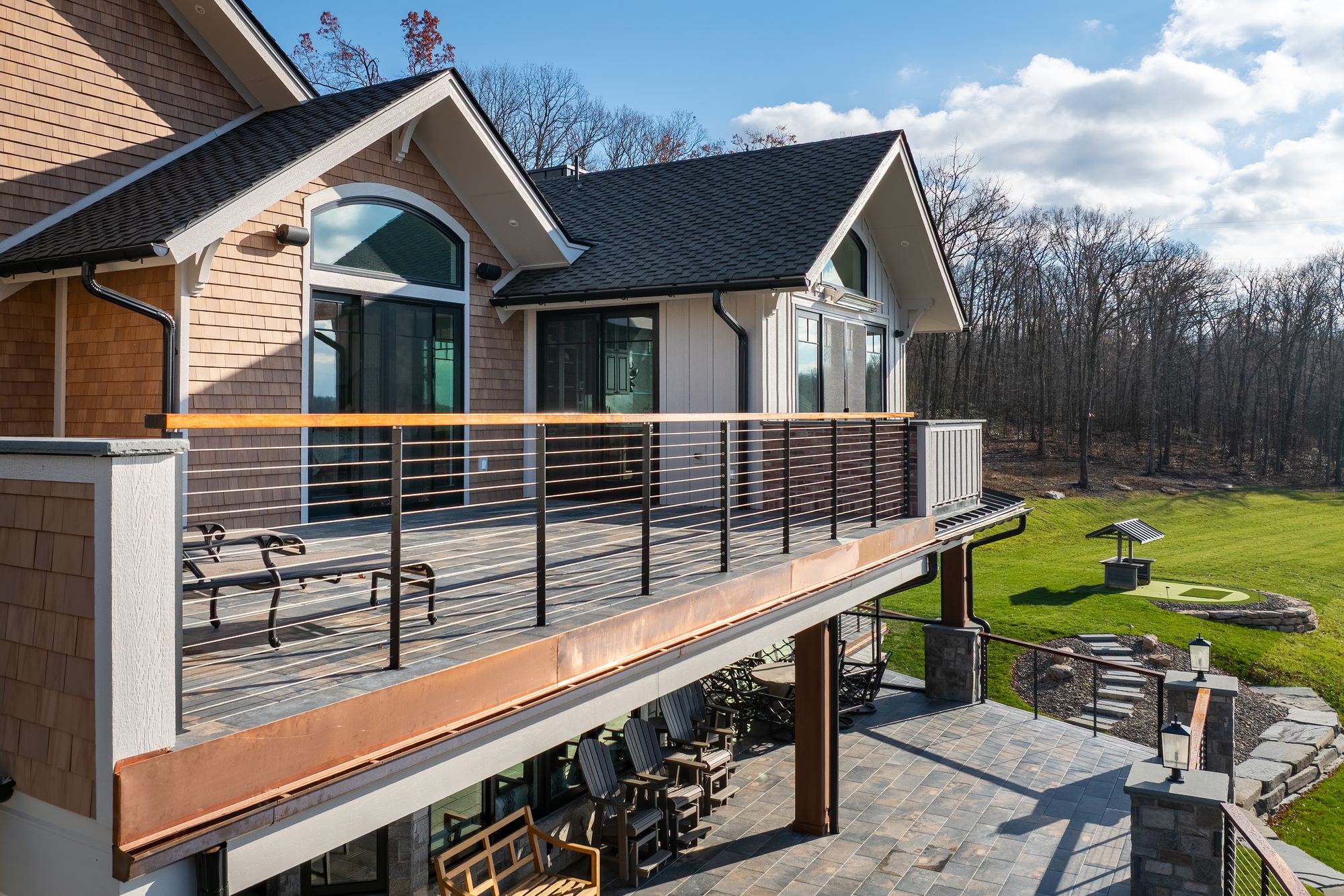 Upper deck with cable railing and a copper fascia above the lower patio