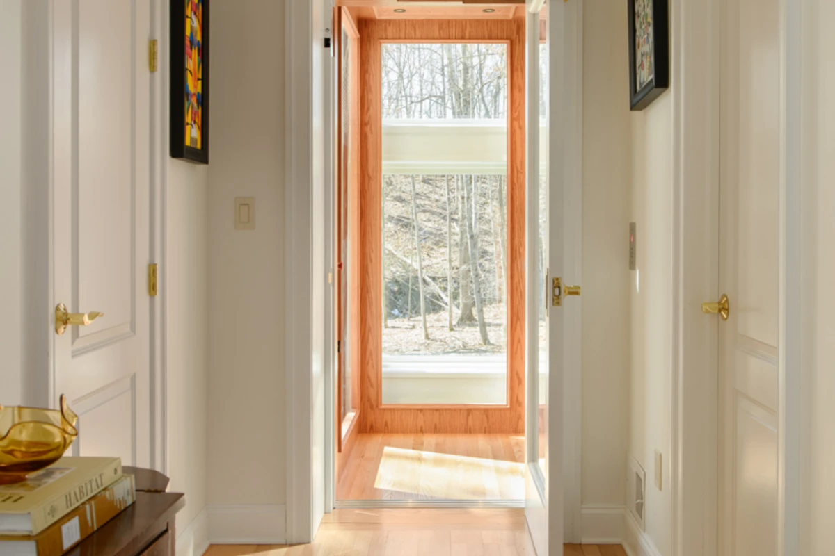An interior doorway cased in stained wood trim