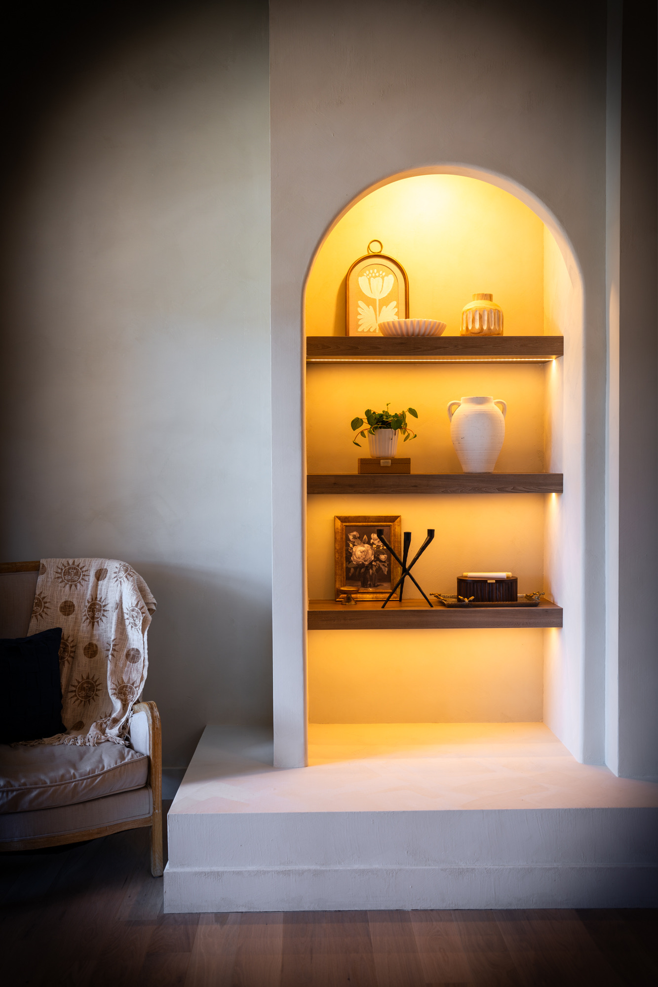 Arched, lit display niche with walnut shelves