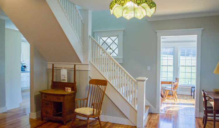 A doorway cased in white-painted trim off a freshly painted hall