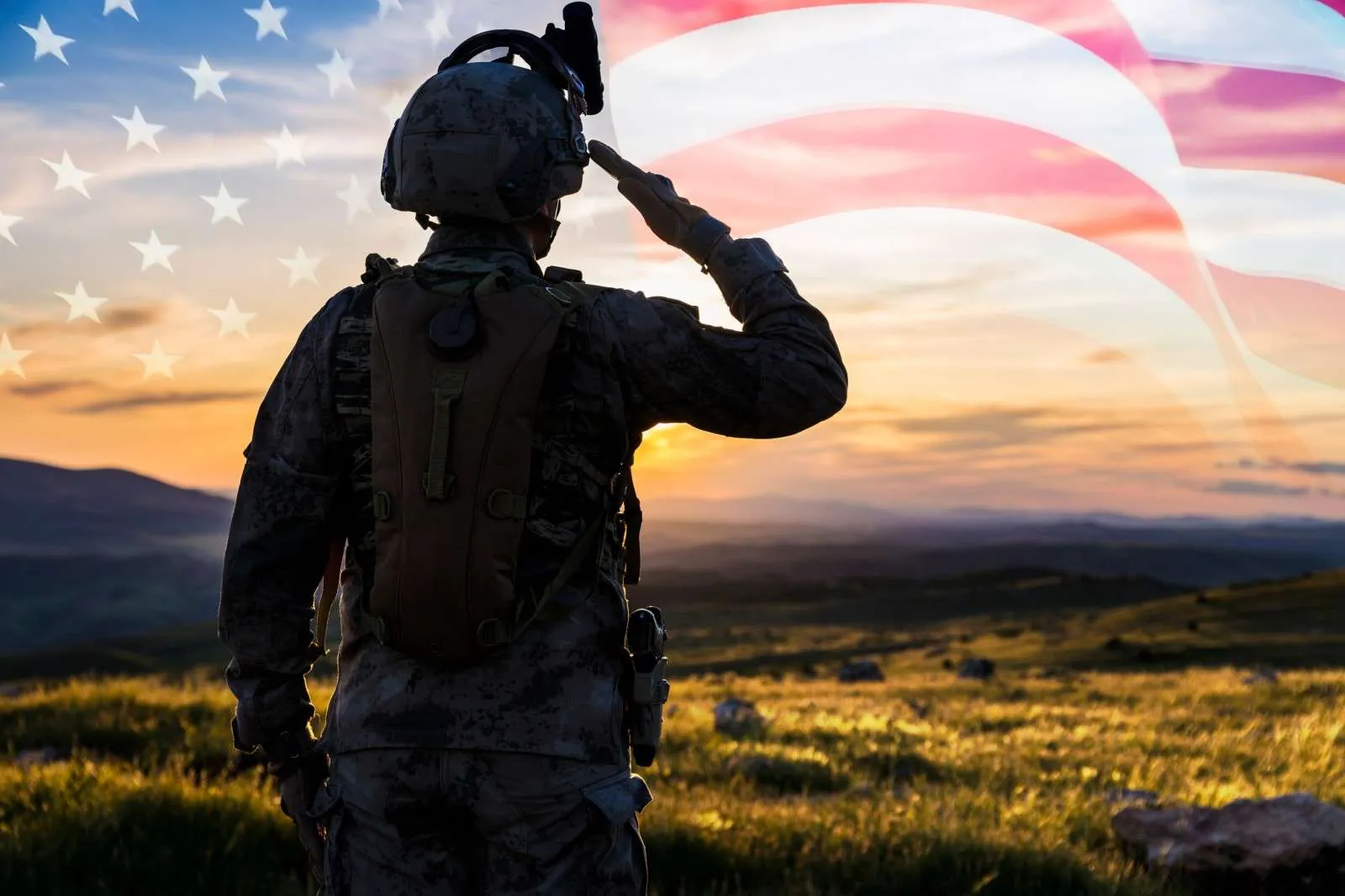 A soldier in uniform saluting at sunset, an American flag across the sky