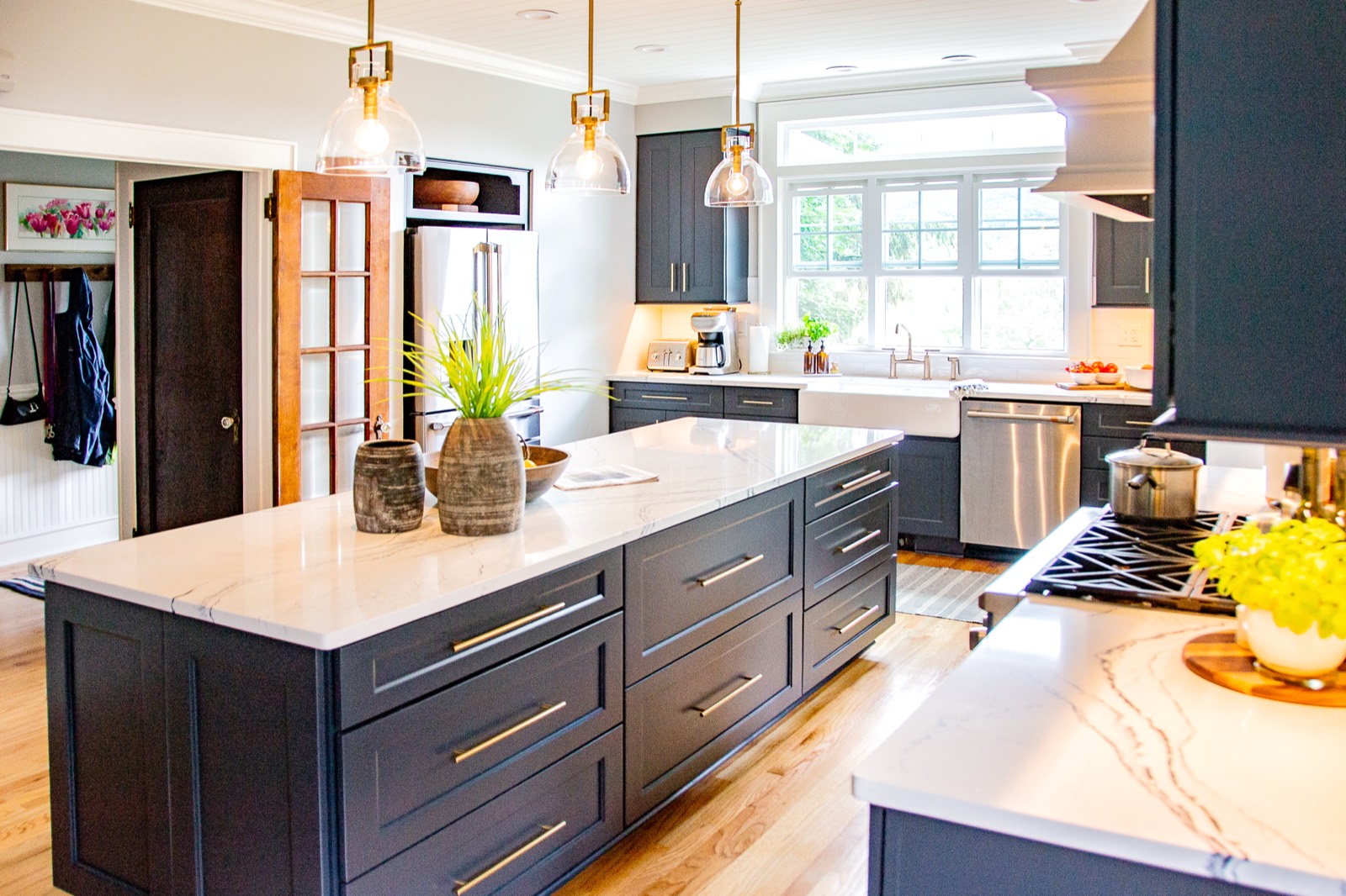 Kitchen island with blue-gray shaker cabinets and white quartz top