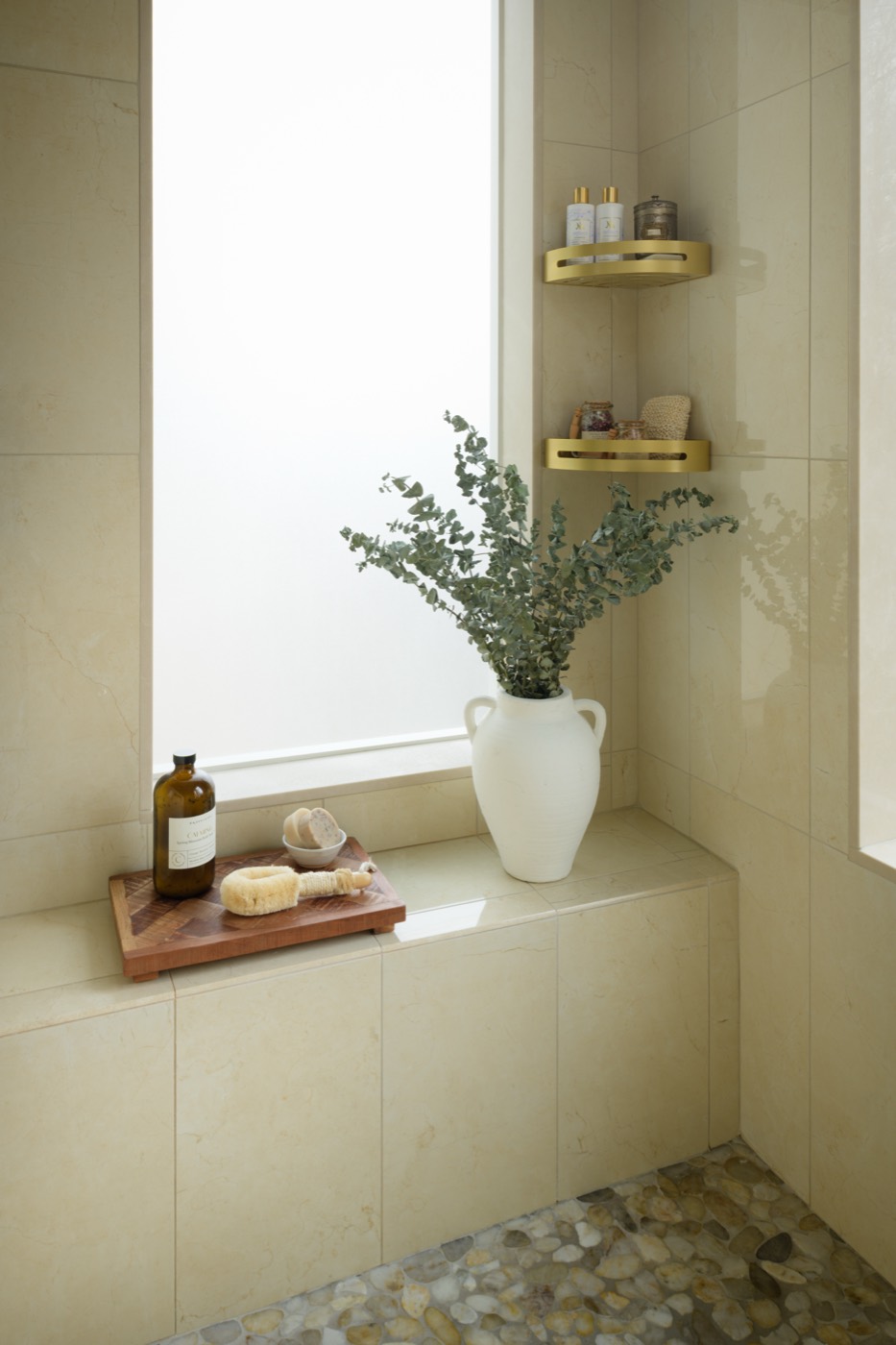 Limestone shower bench with brass shelving