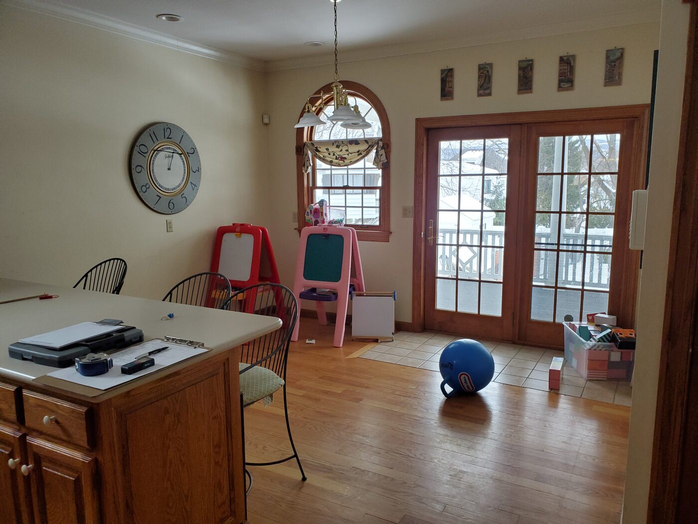 A kitchen before remodeling: dark oak cabinets, a cluttered peninsula and a low ceiling